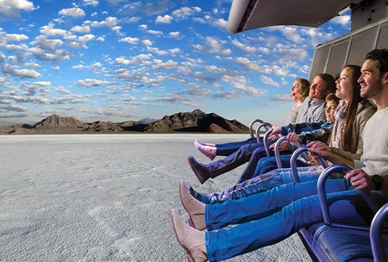 A group of people on a flight ride superimposed over a salt flats landscape.