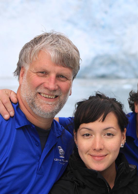 A group of Kenai Fjords Tours workers pose for a photo in front of a glacier