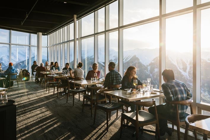 Many people sit and dine alongside floor-to-ceiling windows