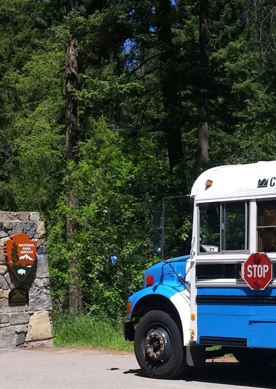 School bus at the Glacier National Park entry sign