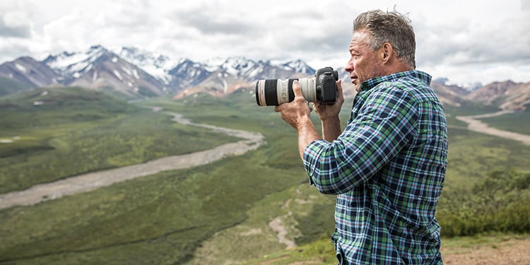 A man with a telephoto camera prepares to take a photo