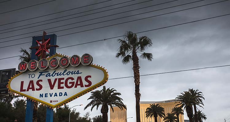 The Las Vegas sign in front of a dark and stormy sky.