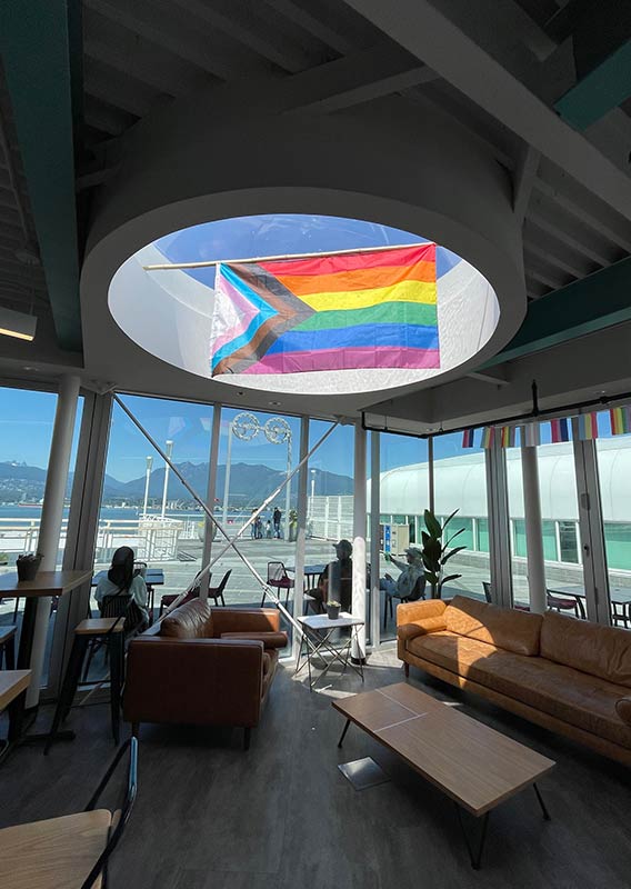 A pride flag hanging under a skylight at FlyOver Canada Vancouver.